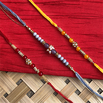 classy Red, Yellow, Grey pearl Rakhi set of 3 for bhaiya bhabhi