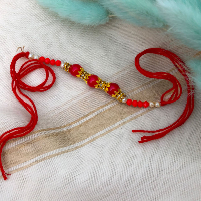 simple sober red pearl full Dora Rakhi for bhaiya bhabhi