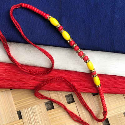 Beautiful yellow and red beads with pearl Rakhi for brother